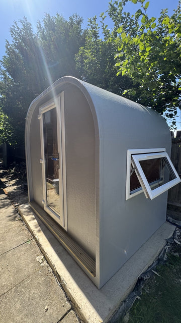 Grey GRP garden office pod under 2.5m tall installed on a concrete base
