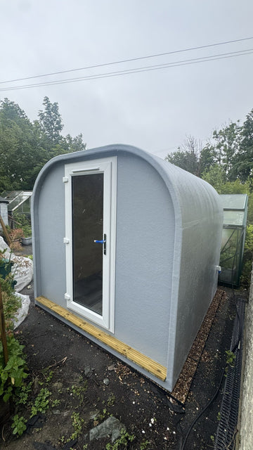 Seamless grey GRP fibreglass garden office pod installed in a garden