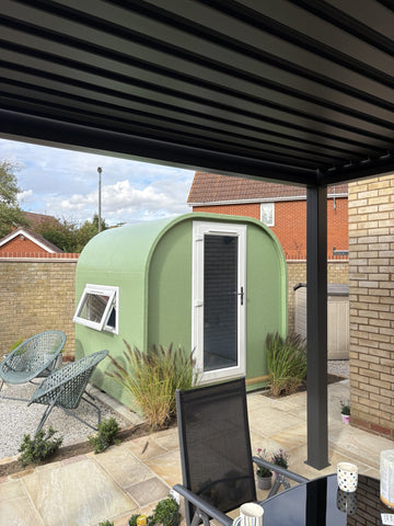 Sage green GRP fibreglass garden office pod installed on a landscaped patio